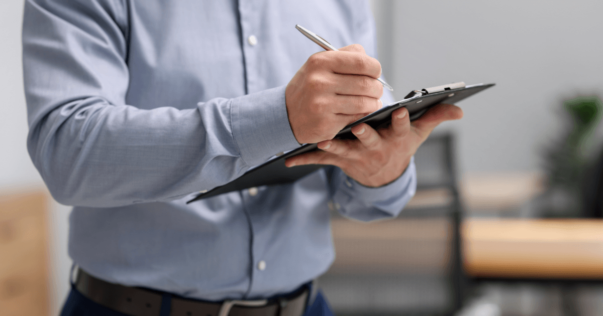 Person reviewing and signing documents on a clipboard