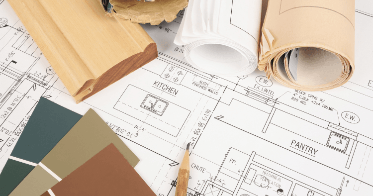 Blueprint plans with paint swatches and wood trim samples for a property improvement project