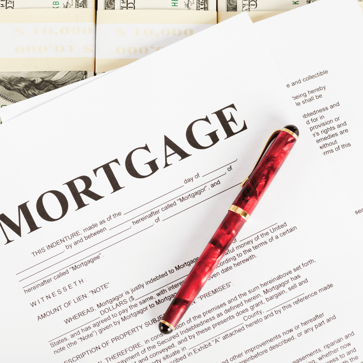 A mortgage document with a red and gold fountain pen resting on top, surrounded by bundled stacks of cash labelled $10,000.