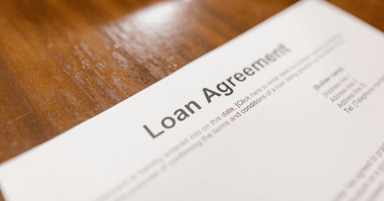 Close-up of a loan agreement document lying on a wooden table